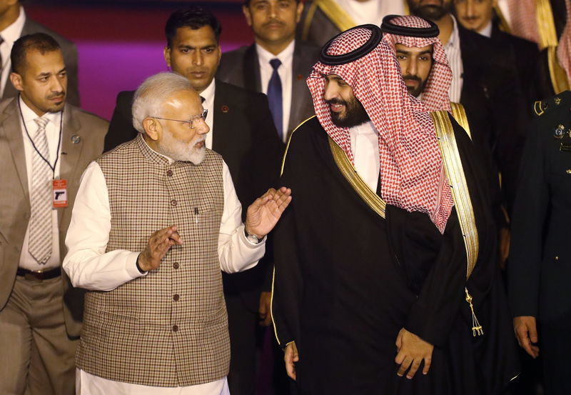 India's Prime Minister Narendra Modi talks to Saudi Arabia's Crown Prince Mohammed bin Salman upon his arrival at an airport in New Delhi
